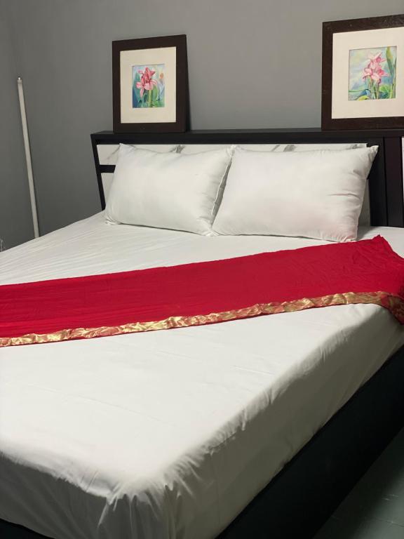 a bed with white pillows and a red blanket at Saran Hostel krabi Thailand in Krabi town