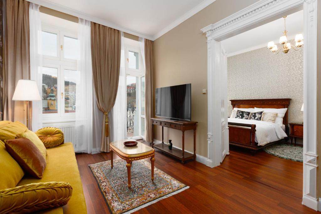 un salon avec un lit et une télévision dans l'établissement REZIDENCE MAKART, à Karlovy Vary