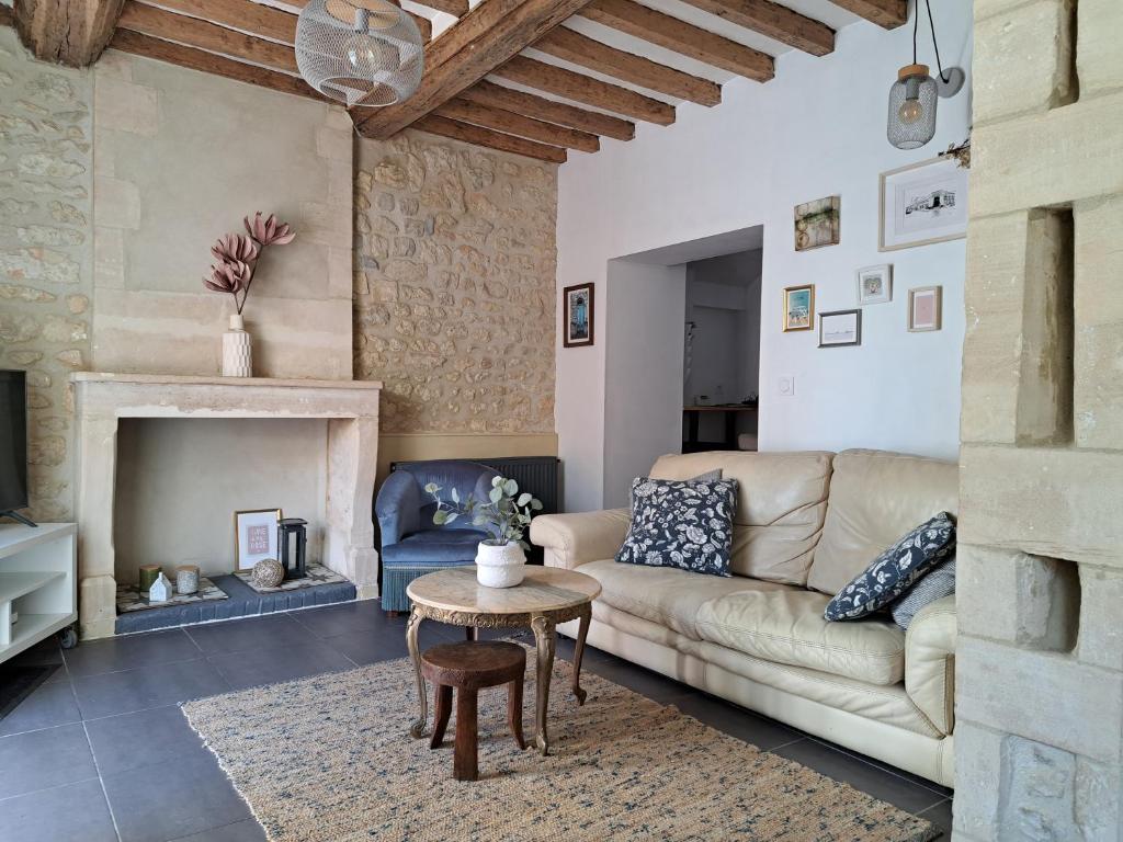 uma sala de estar com um sofá e uma mesa em La petite bajocasse em Bayeux