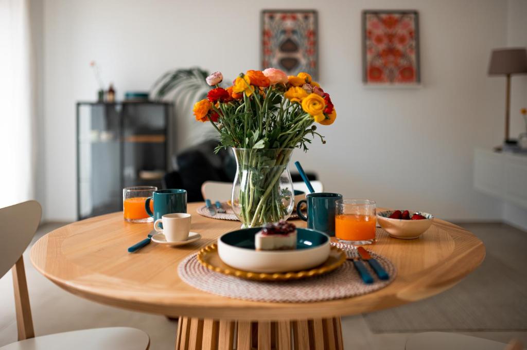 a table with a vase of flowers and a plate of food at Silvia’s Home in Monopoli