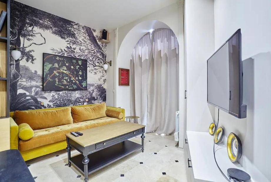a living room with a couch and a tv at 299 Suite Nansouty - Superbe Appartement à Paris in Paris