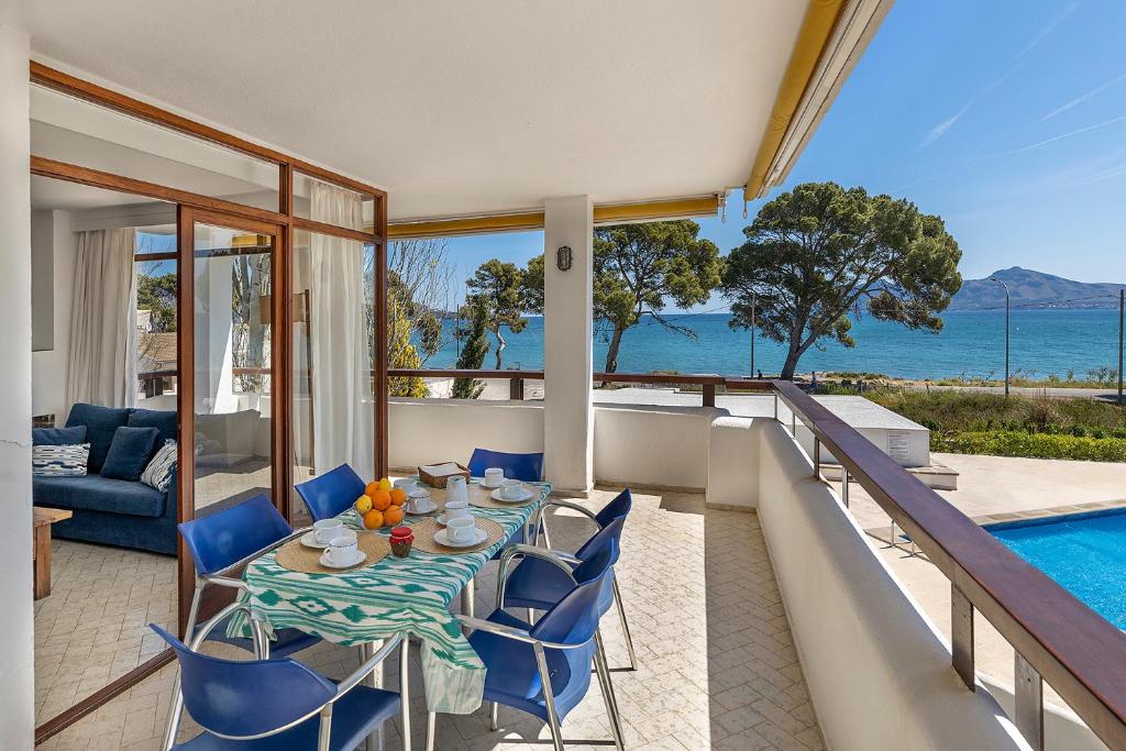 Un patio con mesa y sillas y una piscina. en Llenaire 1, sea view, pool, wifi, en Puerto Pollensa