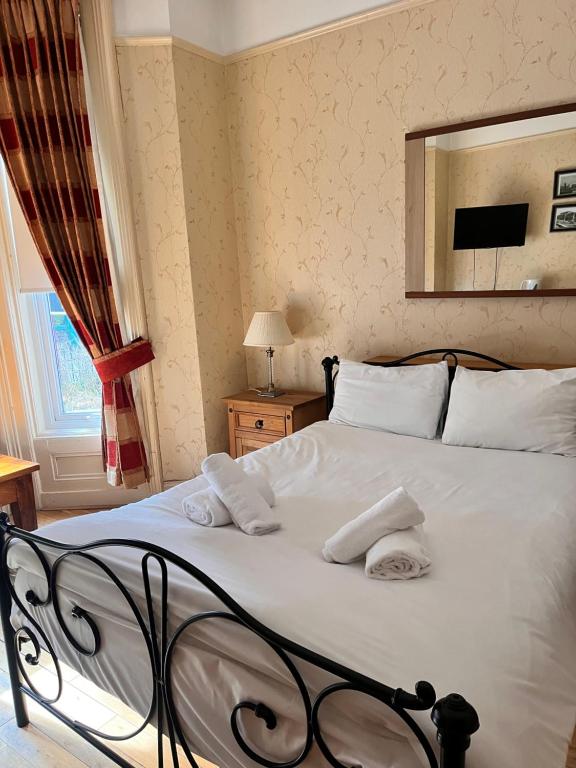 a bedroom with a bed with two towels on it at Beech Mount Grove Suites in Liverpool