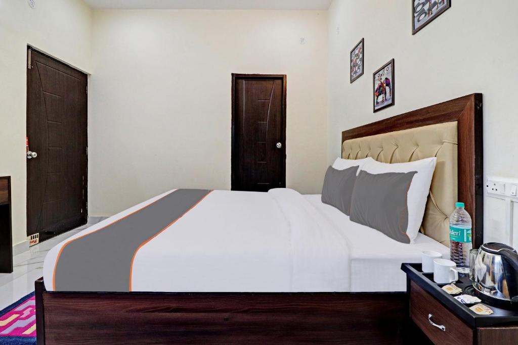 a bedroom with a large white bed and wooden furniture at Super OYO Capital O Maira Heights in Dehradun