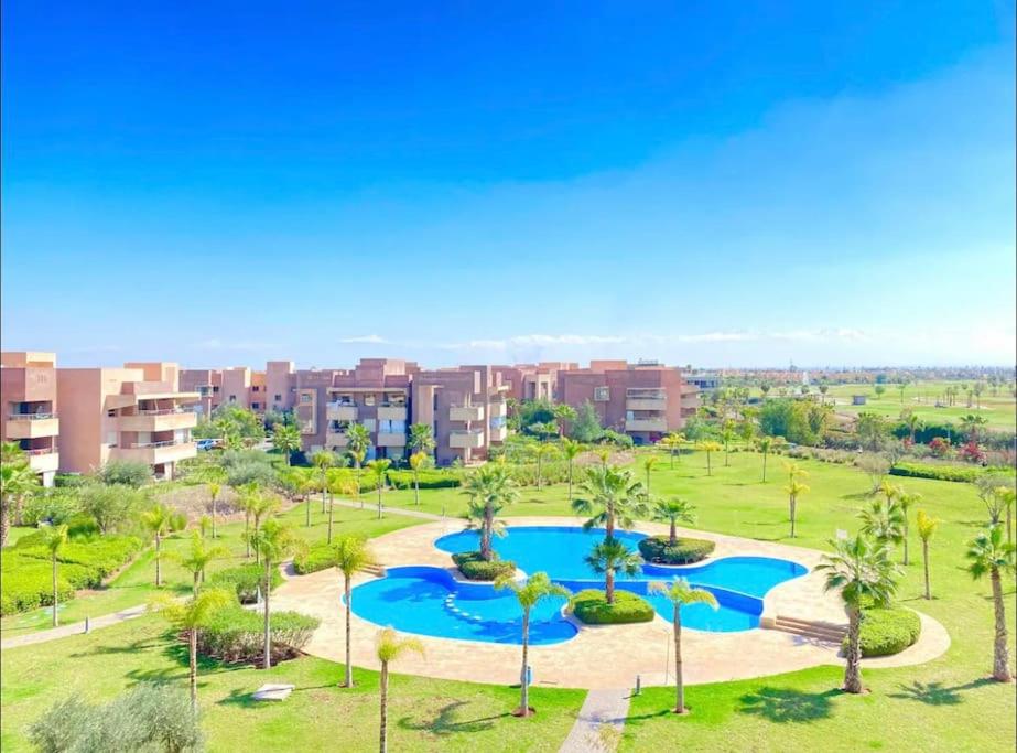 - une vue aérienne sur un complexe avec une piscine et des palmiers dans l'établissement Prestigia Golf entrée Agate (wifi), à Marrakech