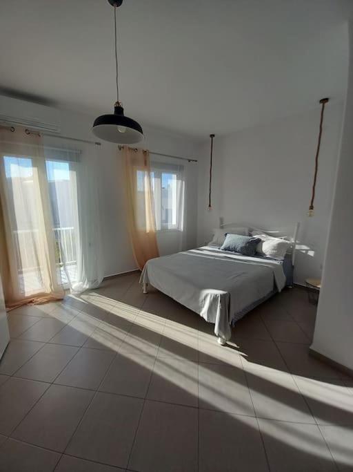 Mariam House في باريكيا: غرفة نوم مع سرير في غرفة مع نوافذ