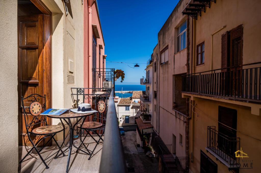 an alley with a table and chairs on a balcony at Casa vacanze Peperoncino in Castellammare del Golfo