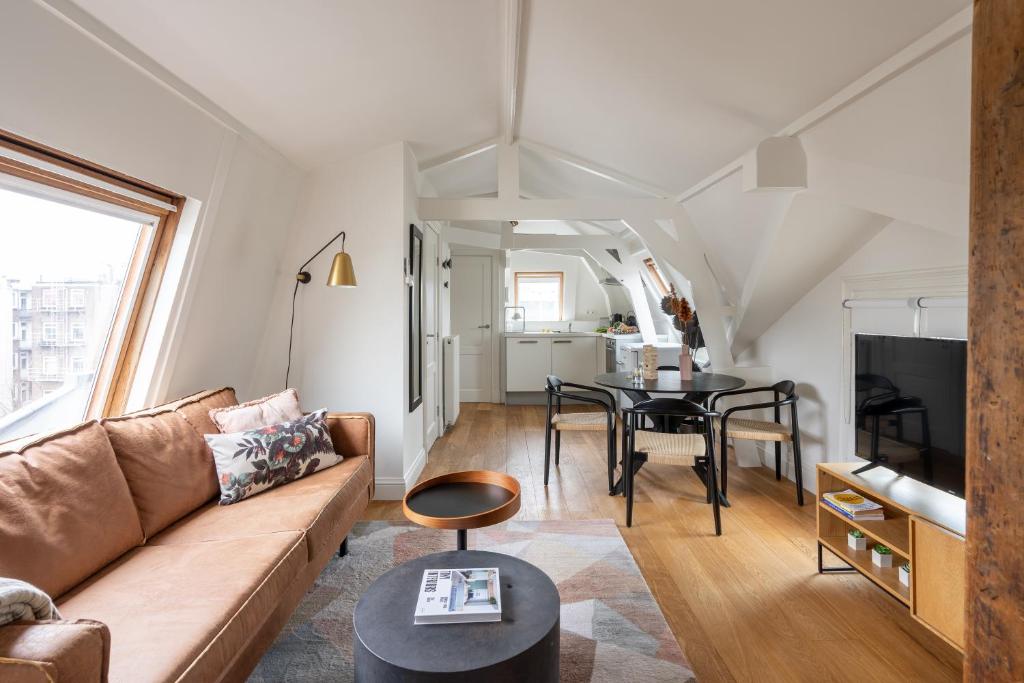 uma sala de estar com um sofá e uma mesa em Yays Amsterdam Vondelpark by Numa em Amesterdão