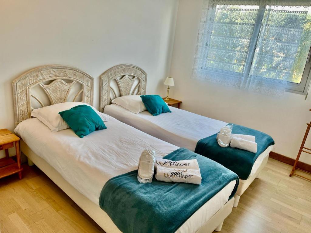2 camas en un dormitorio con almohadas azules en Les Pins YourHostHelper, en Cagnes-sur-Mer