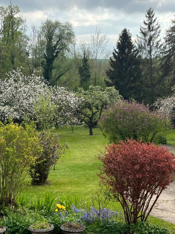 a garden with flowers and trees in the background at Chambre dans jolie nature in Auxi-le-Château