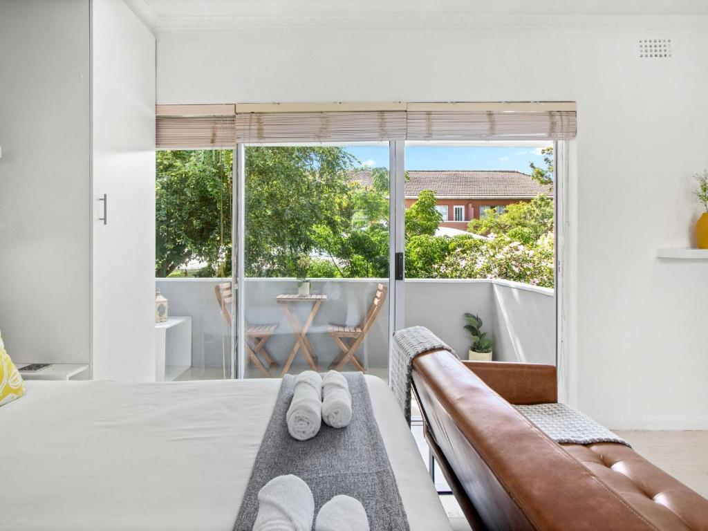a bedroom with a bed and a couch and a balcony at Fairmile Urban Oasis in Cape Town