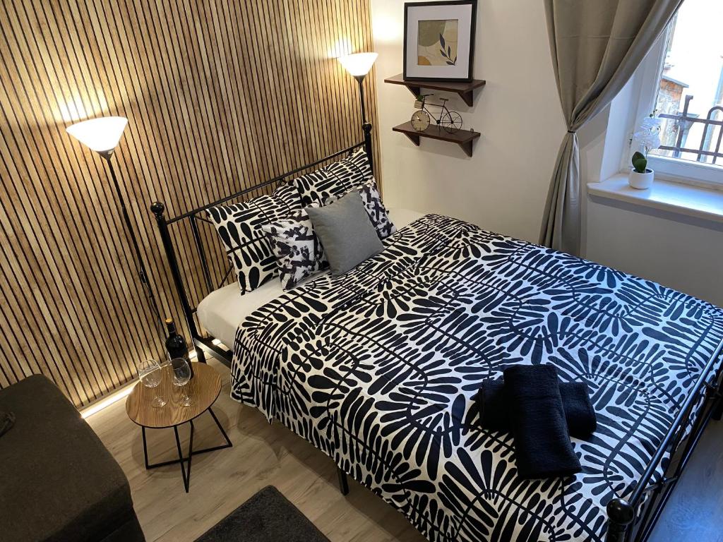 a bedroom with a bed with a black and white comforter at Sparrow Apartment in Kazimierz in Krakow