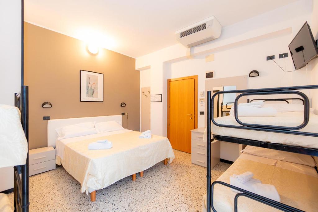 a room with two bunk beds and a bathroom at Hotel Galileo in Rimini