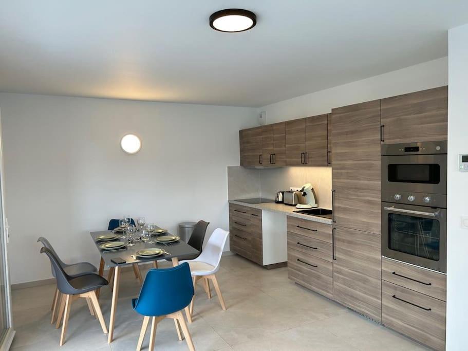 a kitchen with a table and some chairs and a kitchen with at La Villa des Cimes in Pelleautier