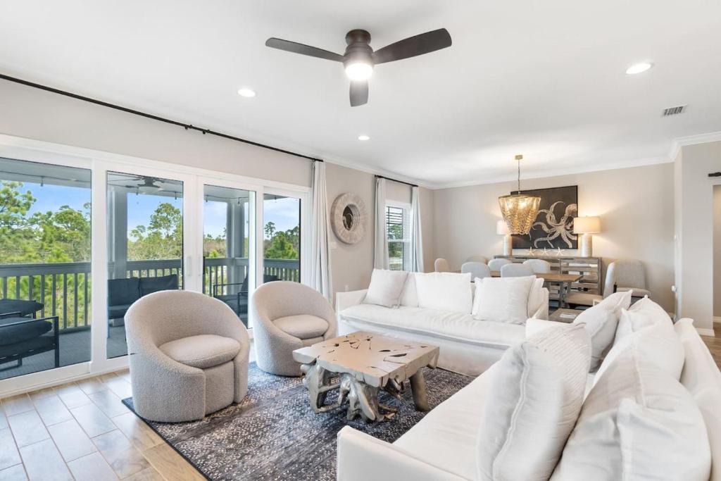 a living room with a white couch and chairs at Living In Luxury in Pensacola
