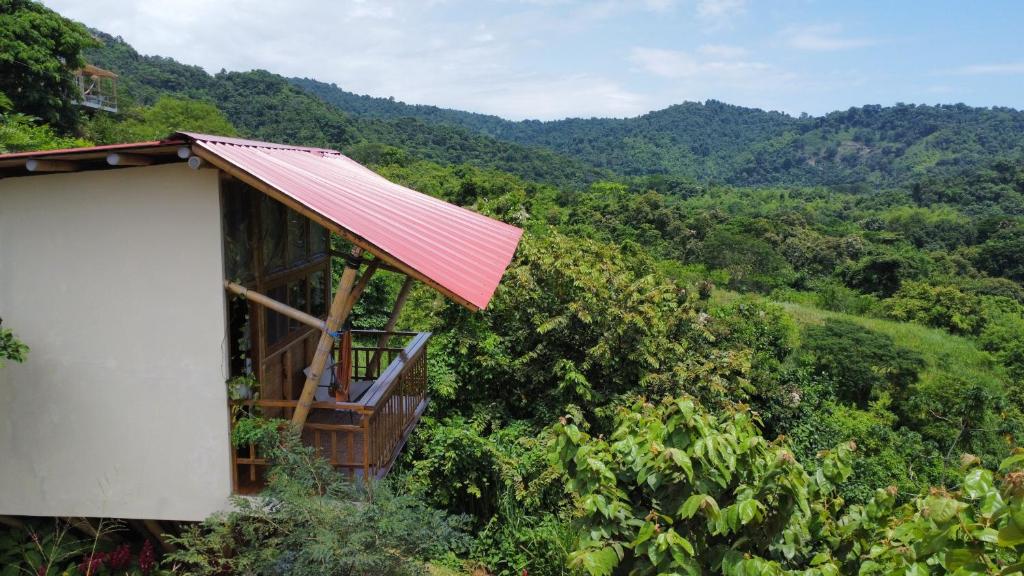 a small house with a red roof on a hill at Bungalows Ayampe in Ayampe
