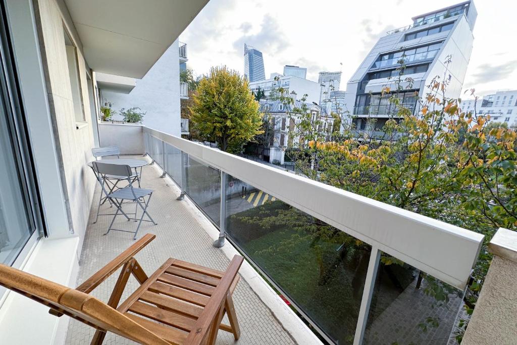 uma varanda com duas cadeiras e uma mesa em Courbevoie - Normandie - La Défense em Courbevoie