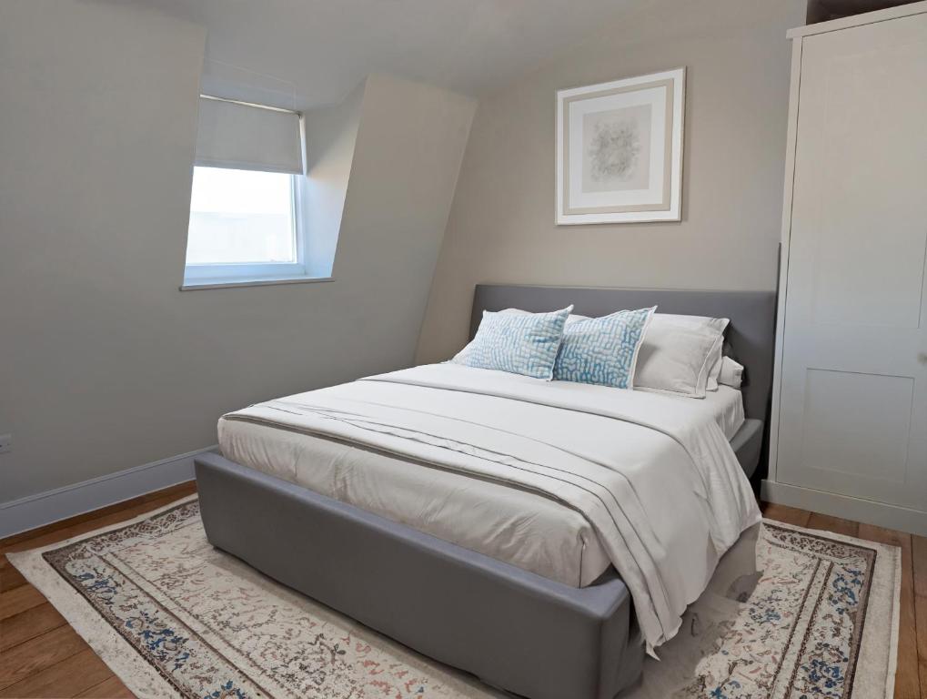 a bedroom with a bed with a rug and a window at Townhouse near Spitalfields Market in London