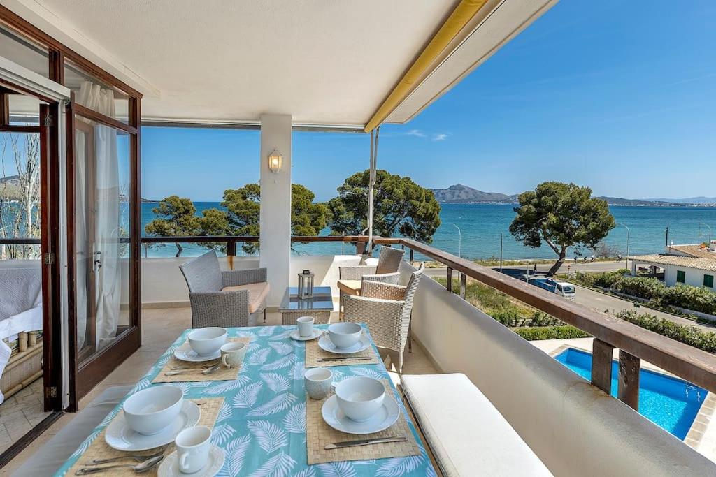 a table on a balcony with a view of the ocean at Llenaire 2, Sea view, pool, AC in Port de Pollensa