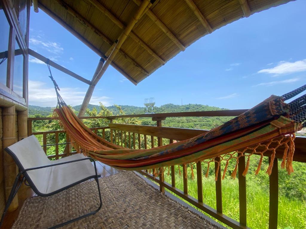 a hammock on the porch of a house at Bungalows Ayampe in Ayampe