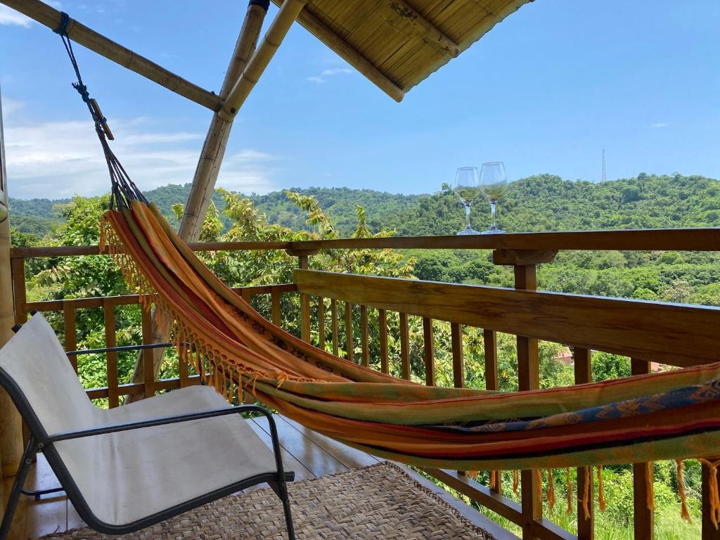 a hammock and a chair on a porch at Bungalows Ayampe in Ayampe