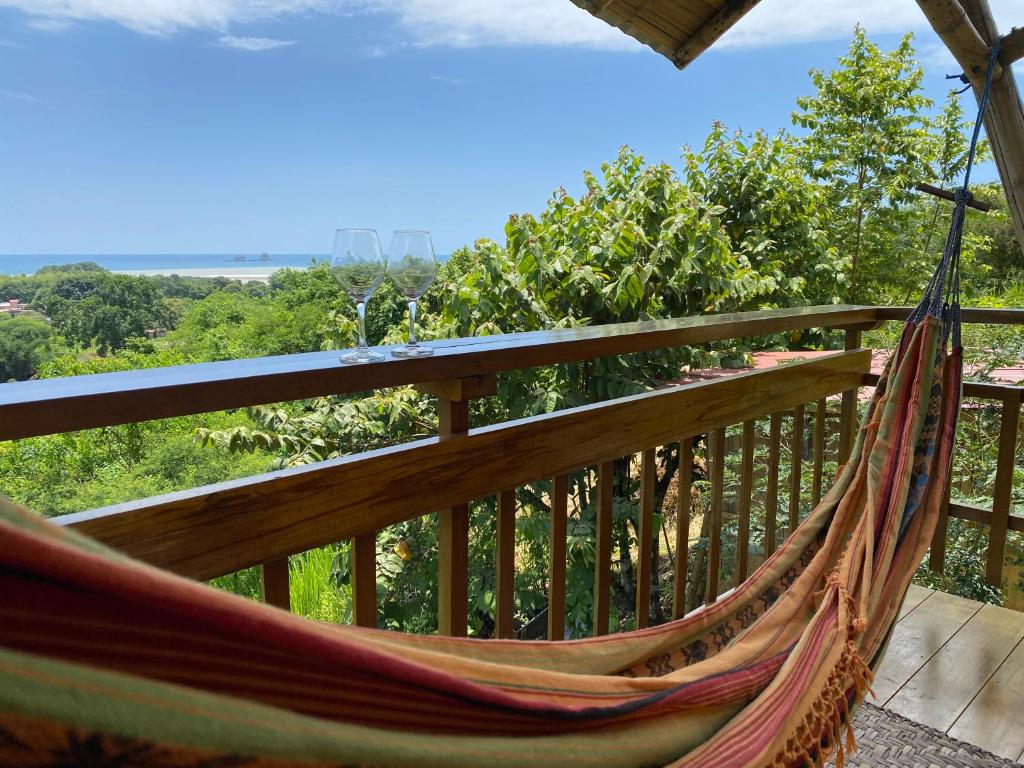 a hammock on a balcony with a view at Bungalows Ayampe in Ayampe