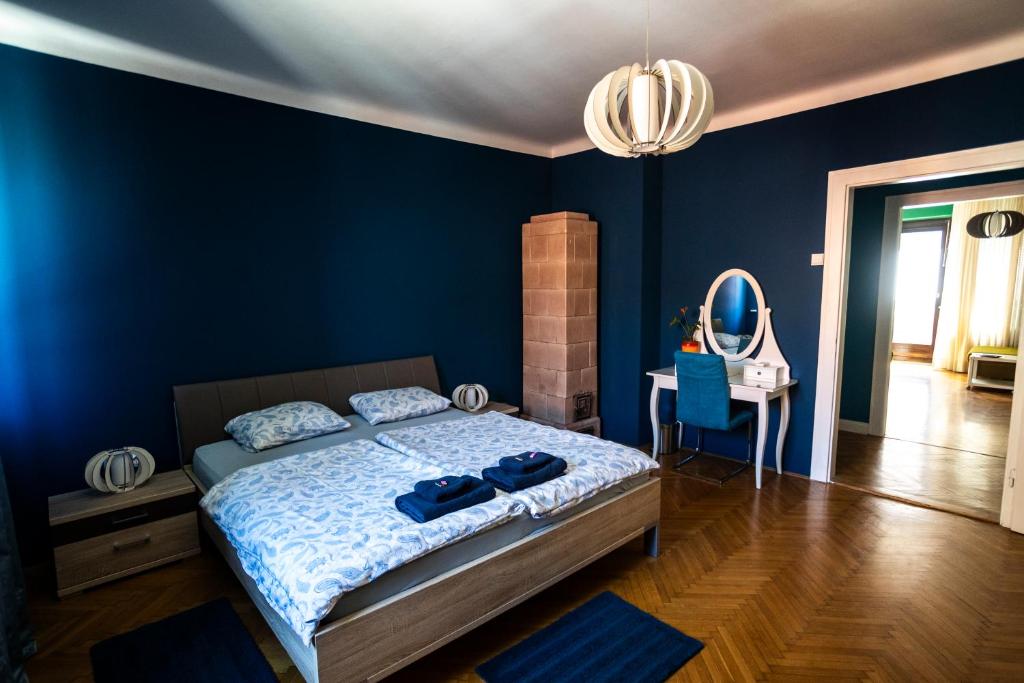a blue bedroom with a bed and a mirror at Cozy apartment in heart of Maribor / big terrace in Maribor