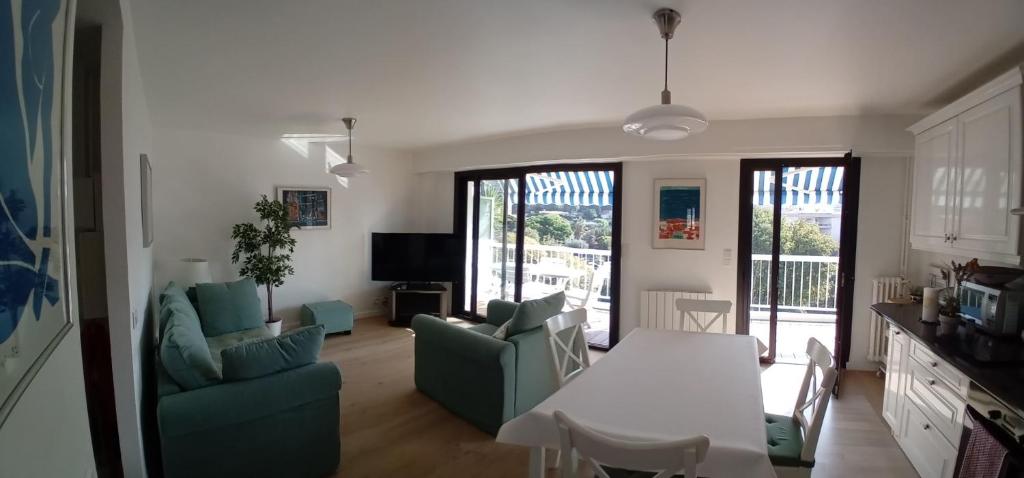 een keuken en een woonkamer met een tafel en stoelen bij Spacious 70 m flat with Balcony and sea view! in Cannes