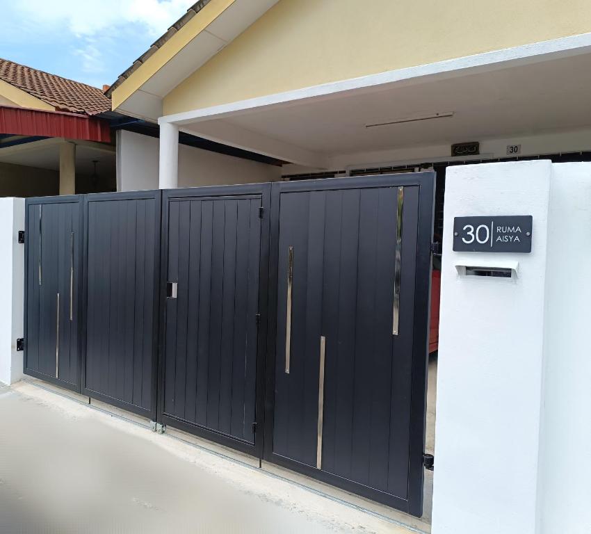 a row of black gates in front of a house at Indera Sempurna Ruma Aisya in Kuantan