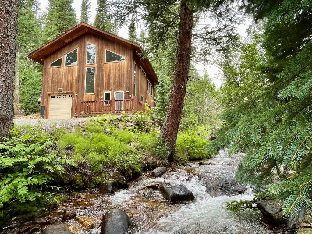 eine Hütte im Wald neben einem Bach in der Unterkunft Mill Creek Cabin - Dumont in Dumont