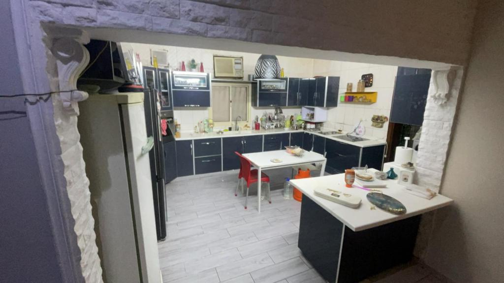 a kitchen with blue cabinets and a white floor at شقة روف in Jeddah