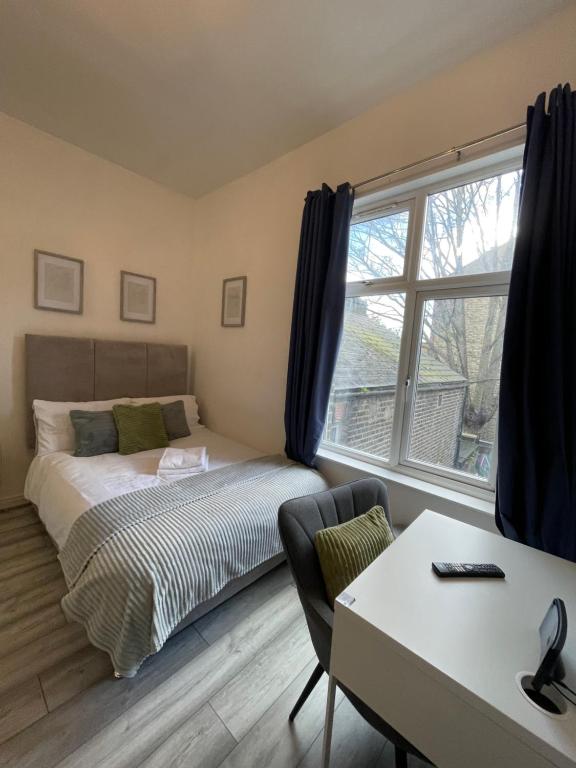 een slaapkamer met een bed, een bureau en een raam bij Camberwell Living Studio - Zone 2 London in Londen