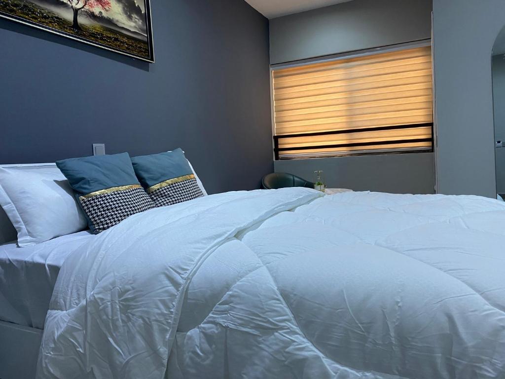 1 cama blanca grande en un dormitorio con ventana en Sylz Residence Studio 5 - 5 Mins from Labadi & Laboma Beaches, en Accra