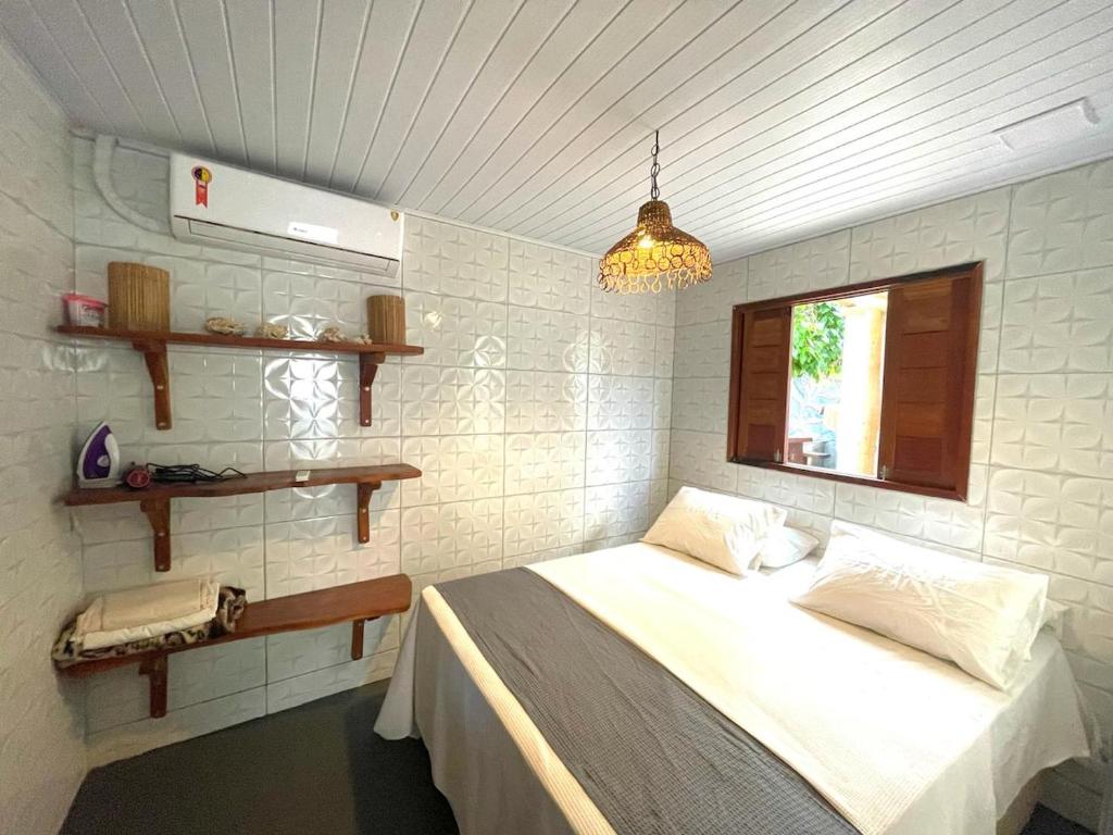a bedroom with a bed and a window at Chalé Palhano Beach in São Miguel dos Milagres