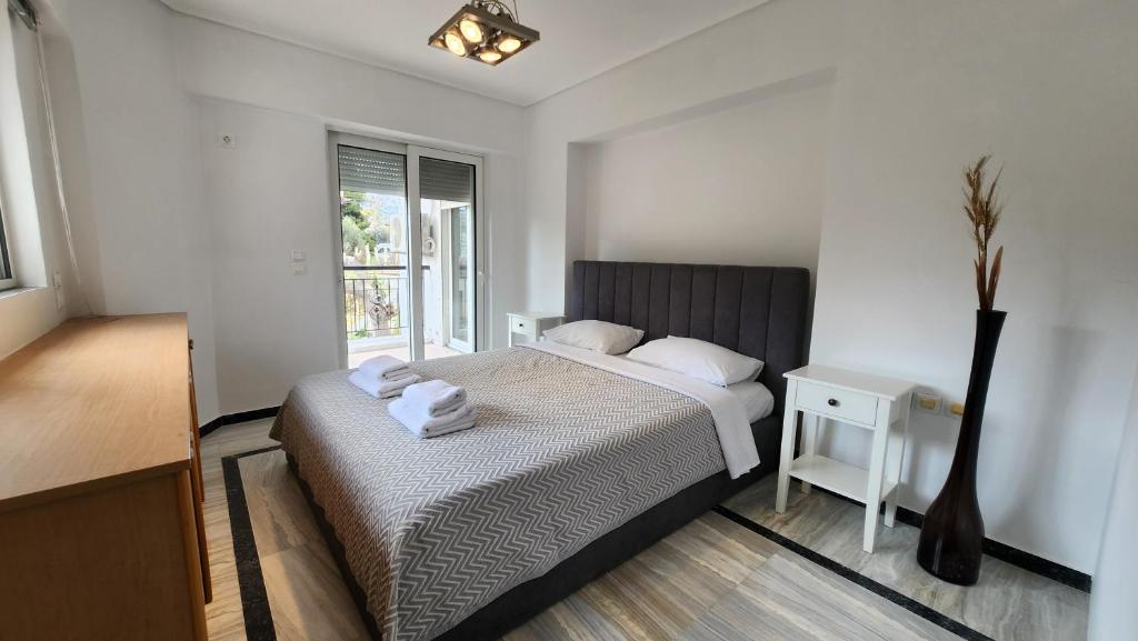 a bedroom with a bed and a table and a window at Nian Apartments - by Avelink in Spáta