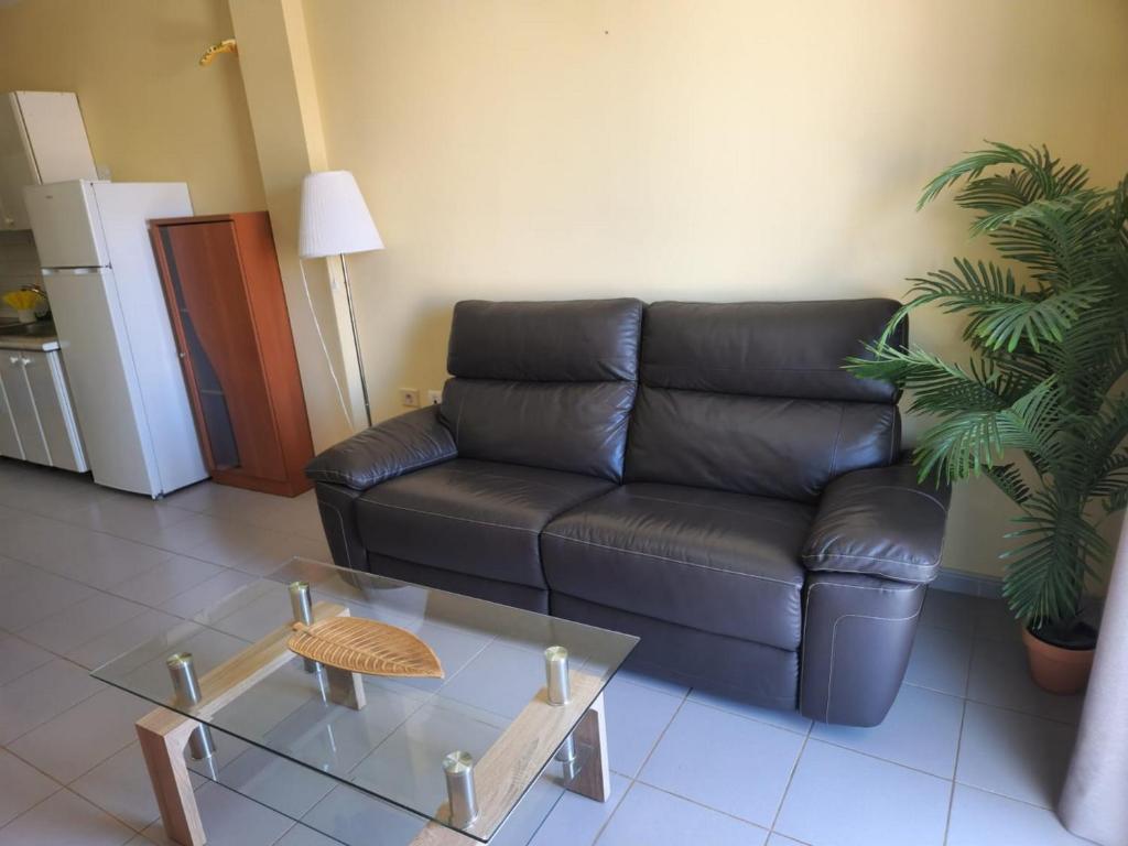 - un salon avec un canapé noir et une table dans l'établissement Vitamina Sea, à Puerto de Santiago