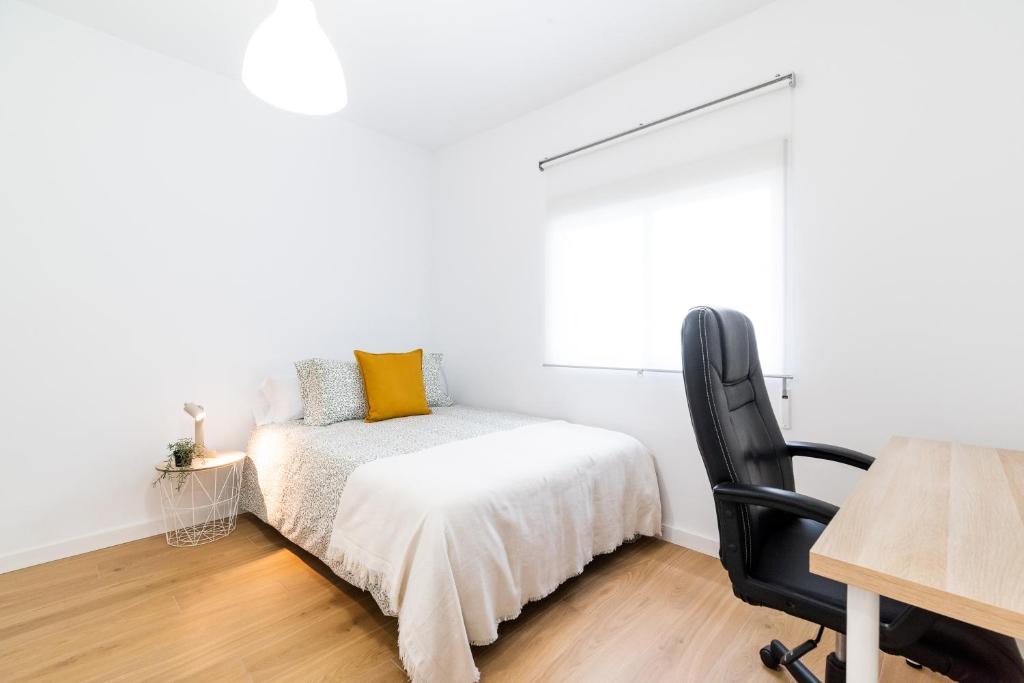 a bedroom with a bed and a desk and a chair at Centro y Confort: Junto a Corte Inglés in Granada