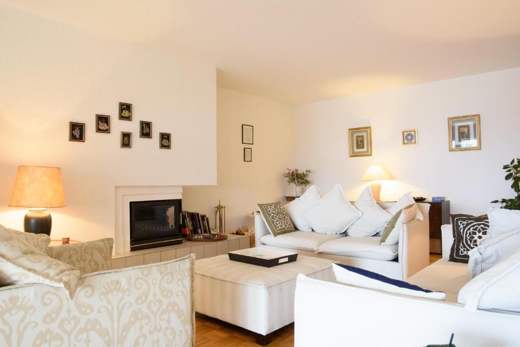 uma sala de estar com um sofá branco e uma lareira em Tourelle 2 - Spacieux appartement dans le centre de Genève em Genebra