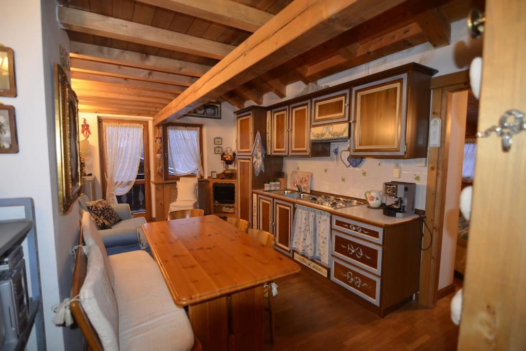 a kitchen with a wooden table in a house at Cozy attic in the center of San Vito in San Vito di Cadore