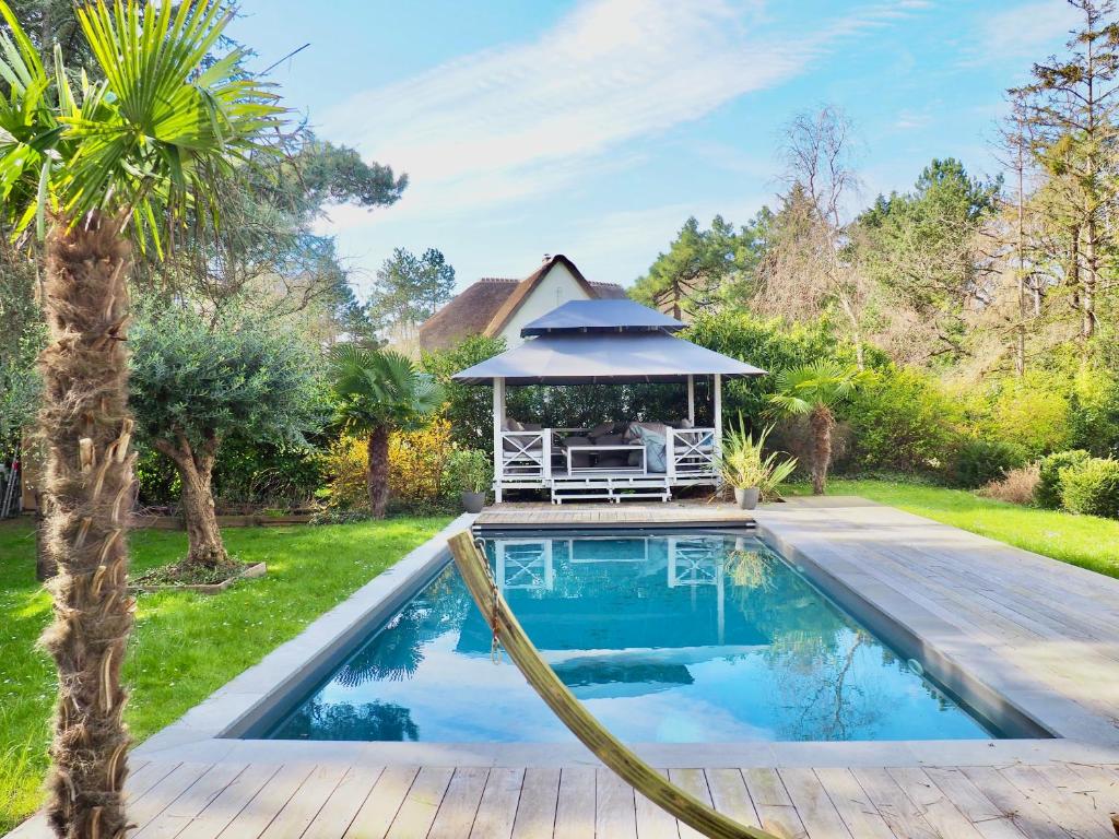 einen Pool mit Pavillon im Hof in der Unterkunft Villa avec piscine au coeur de la forêt in Le Touquet-Paris-Plage