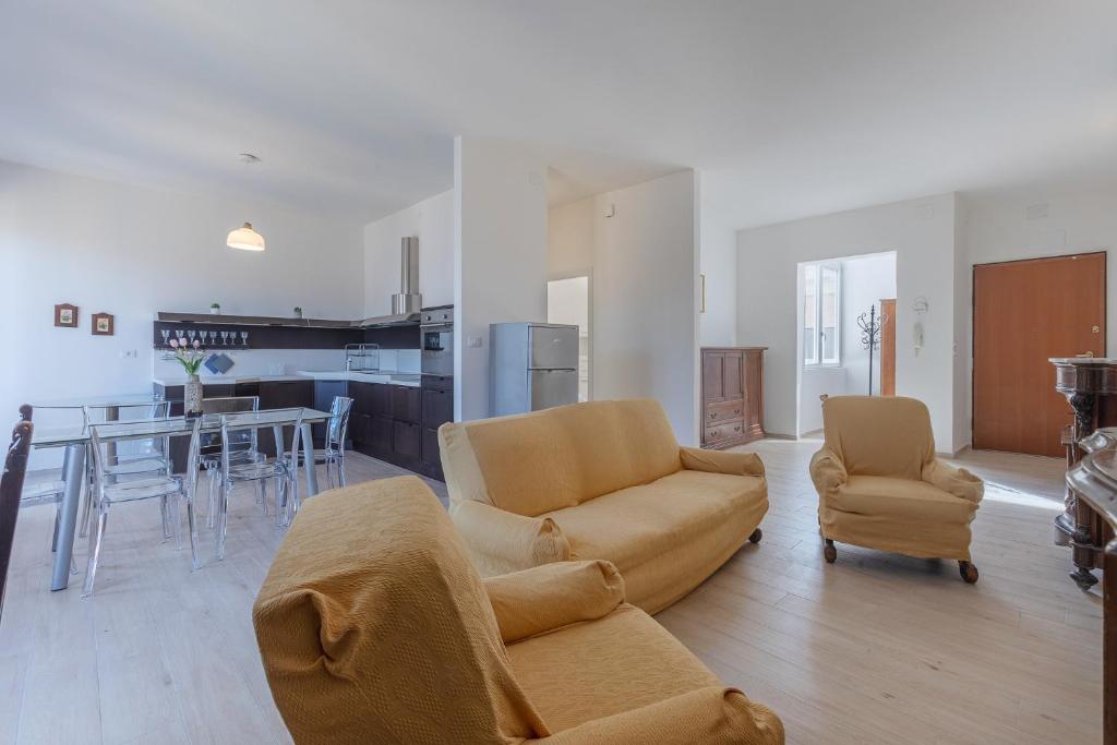 ein Wohnzimmer mit einem Sofa, Stühlen und einem Tisch in der Unterkunft Spacious Apartment x5 with two balconies! in Bologna