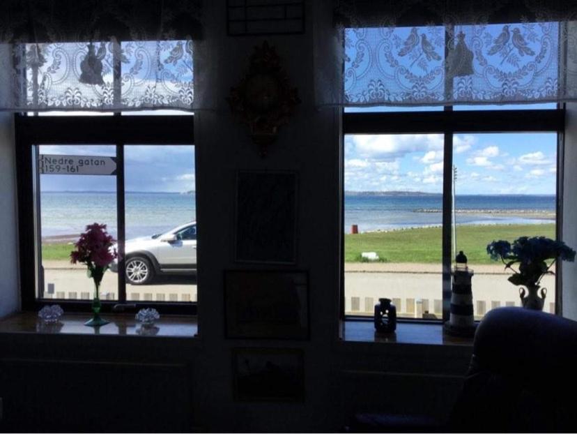a room with three windows with a view of the beach at Sejen by the Sea in Landskrona