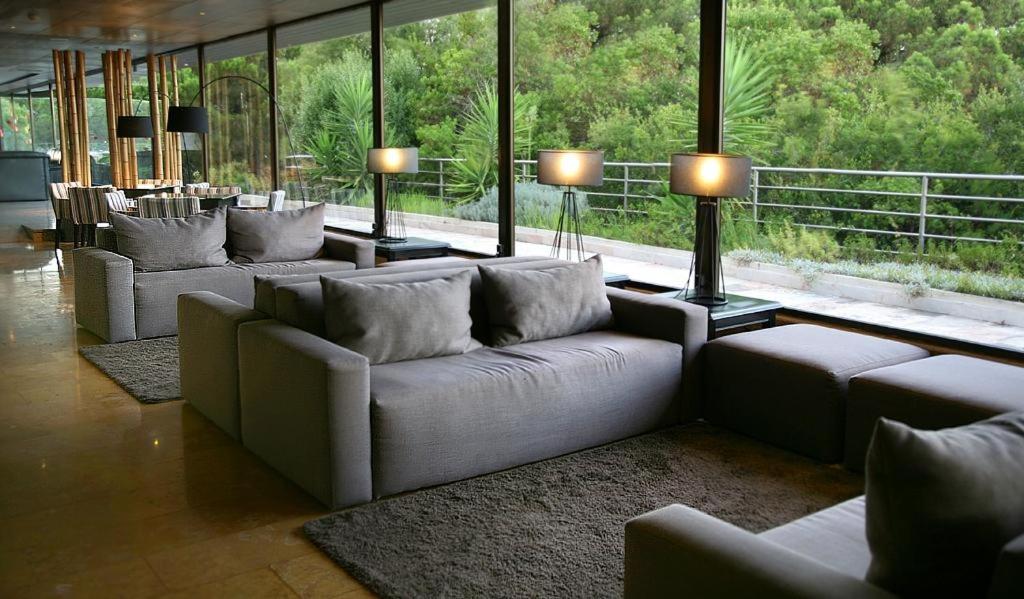una sala de estar con sofás, mesas y ventanas en B&B HOTEL Sado Setúbal en Setúbal