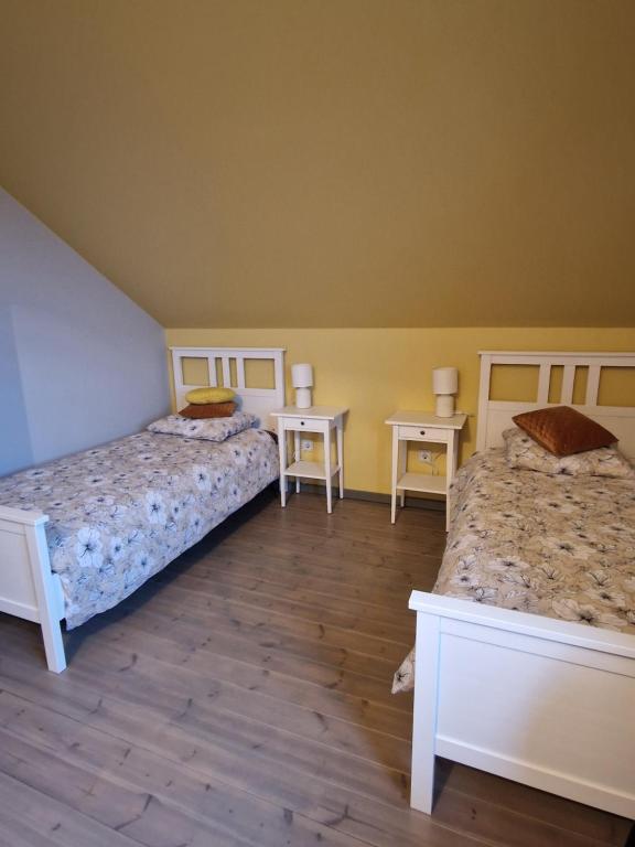 1 Schlafzimmer mit 2 Betten und 2 Tischen in der Unterkunft Bite Le Vanda 