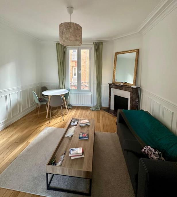 een woonkamer met een bank en een tafel bij Spacieux appartement calme 40m 2 in Parijs