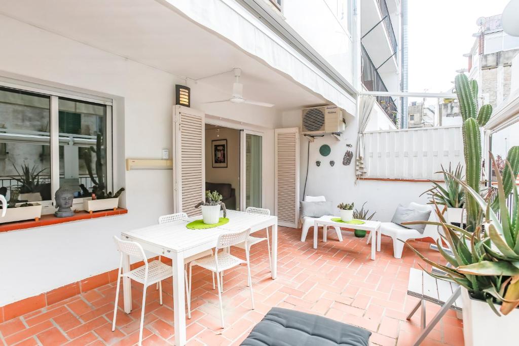 sala de estar con mesa blanca y sillas en CUBAN GREEN Terrace en Sitges