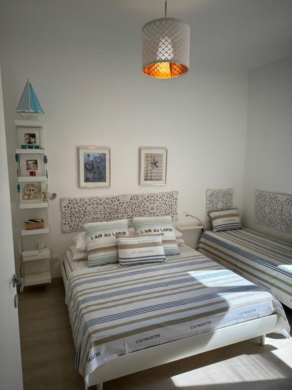 聖溫琴佐的住宿－casalmare，一间卧室配有两张床和吊灯。