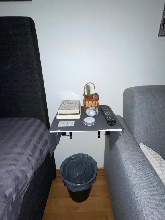 a small table next to a couch with a bed at Mysiga rummet inne i Örebro in Örebro