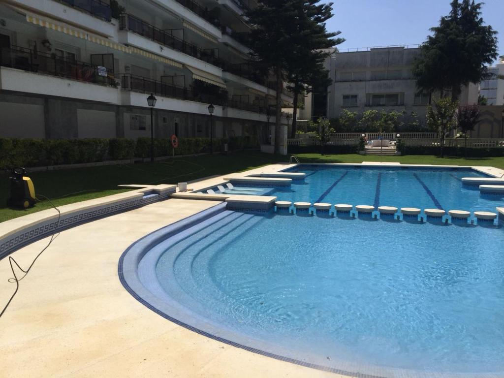 uma piscina vazia em frente a um edifício em Apartamento a 100m de la playa de Fenals - Lloret - Margarita em Lloret de Mar