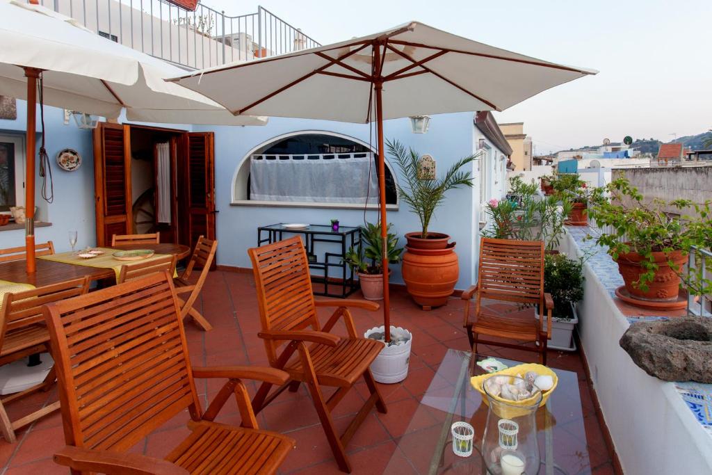 a patio with a table and chairs and an umbrella at Mansarda Garibaldi in Lipari